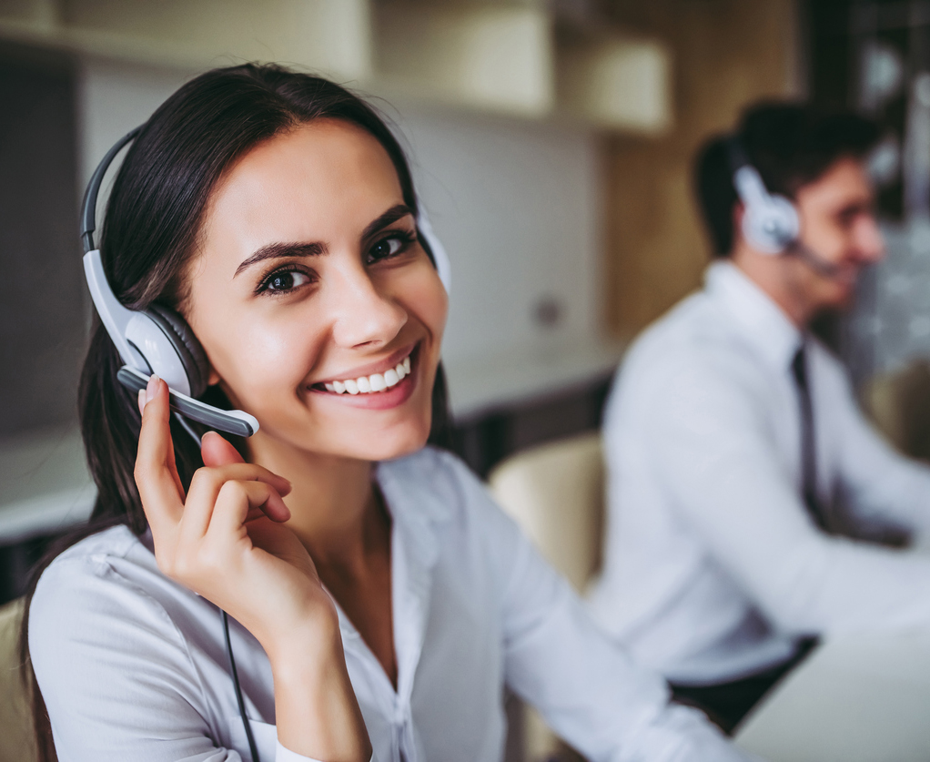 How can I help you? Beautiful call center workers in headphones are working at modern office.